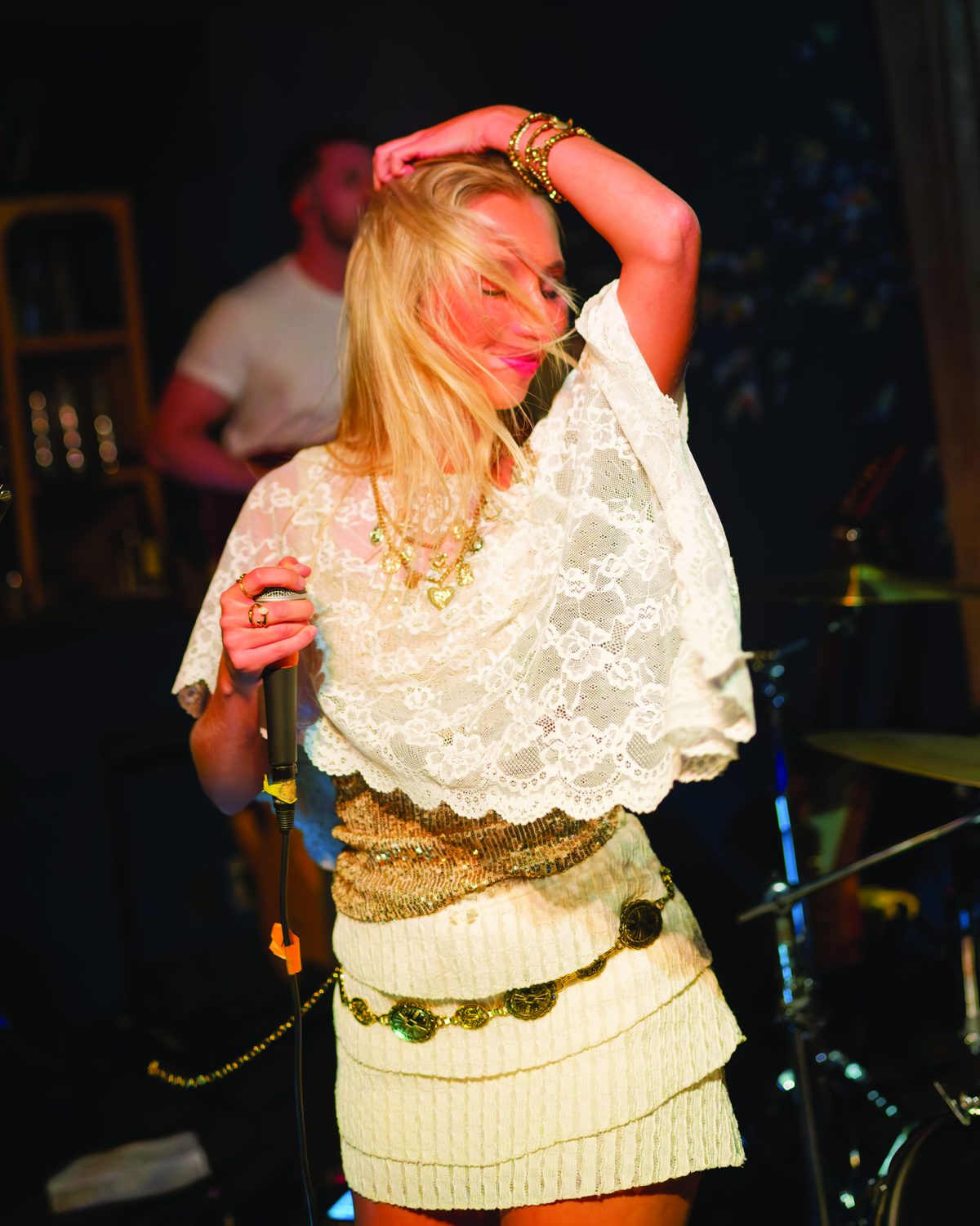 Sylvie dancing with her arm over her head, hair across her face