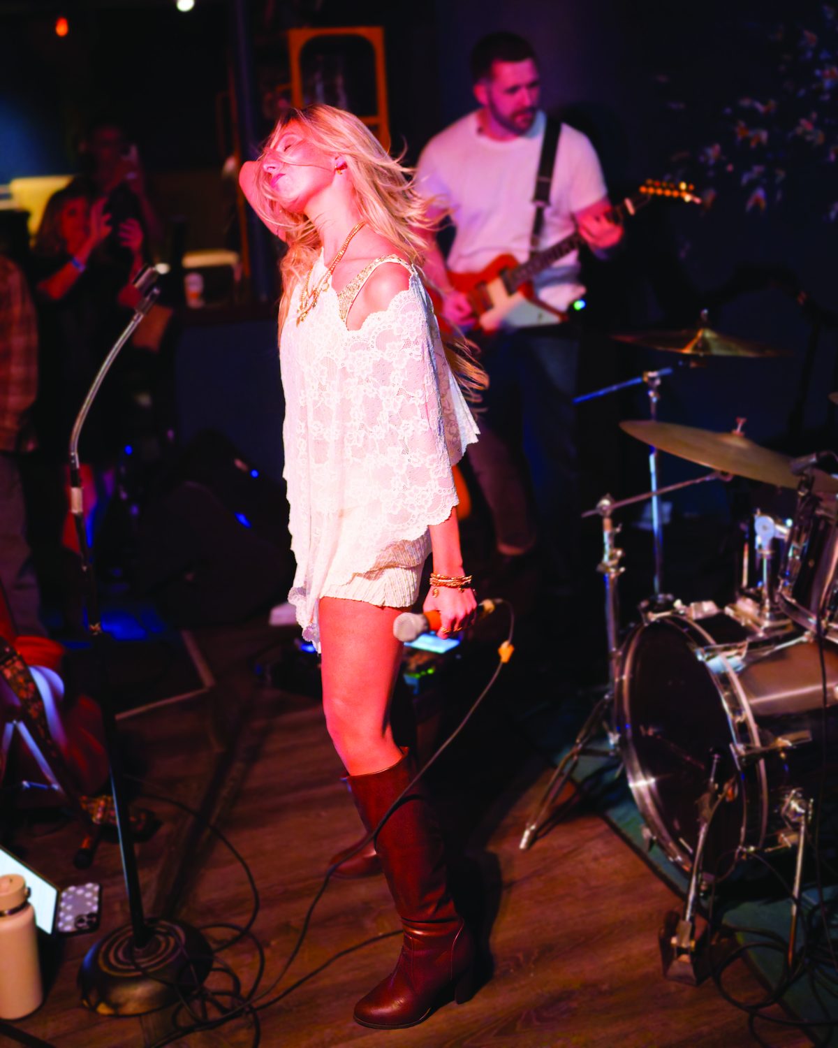 Sylvie on stage in boots with the band behind her